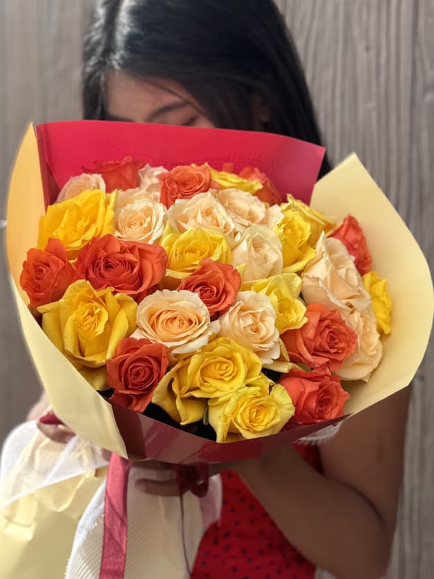 A vibrant bouquet of 31 yellow, orange, and peach Holland roses