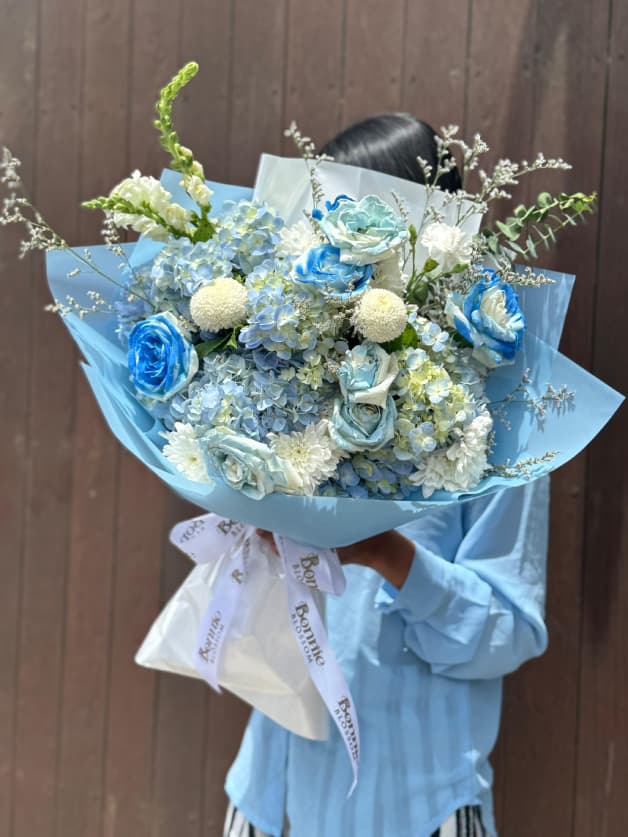A serene bouquet featuring blue roses, hydrangeas, and white chrysanthemums