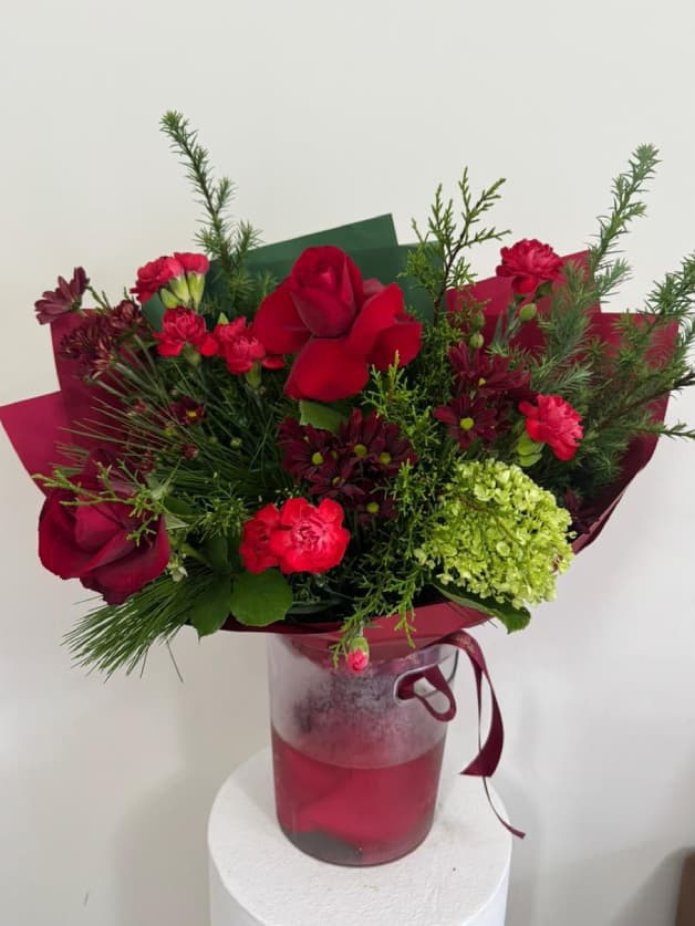 A rich red bouquet with roses, carnations, and green hydrangeas
